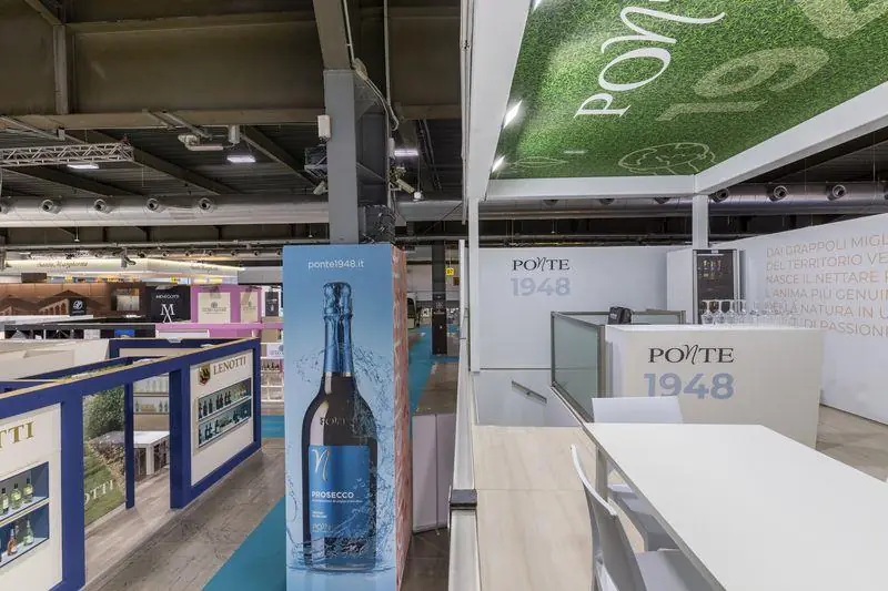 Stand Ponte con grafiche e bottiglia di spumante in una fiera