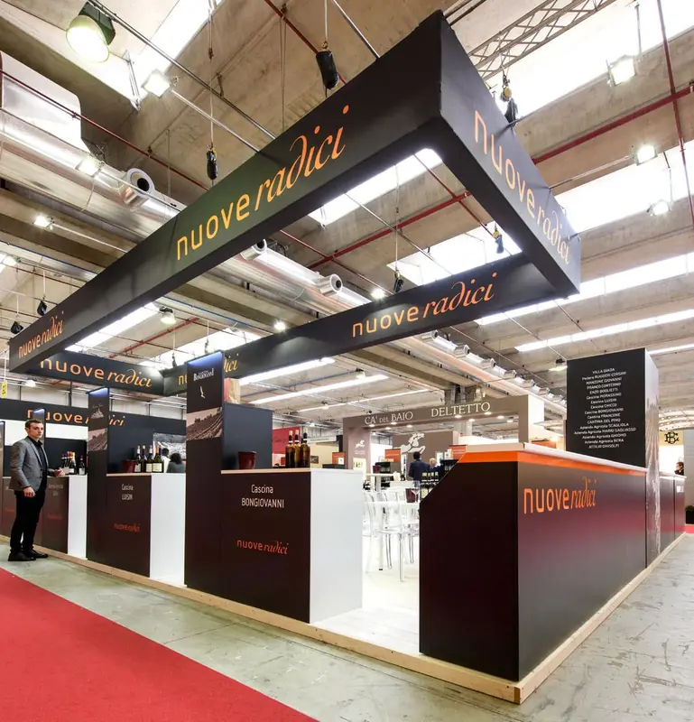 Stand Nuove Radici con insegne nere e moquette rossa