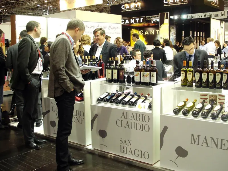 Visitatori davanti a vetrine con bottiglie di vino