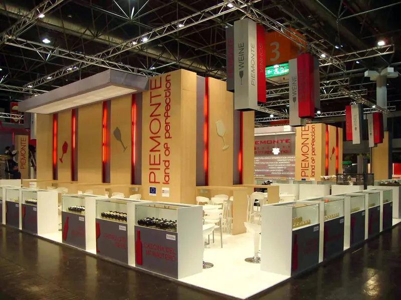 Veduta d'insieme dello stand Piemonte con totem rossi e banchi di degustazione